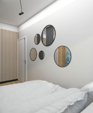 Sypialnia z drewnianą szafą i okrągłymi lustrami na ścianie
