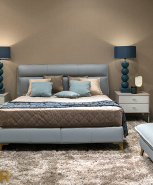 Sypialnia z niebieskim łóżkiem i dużą pufą