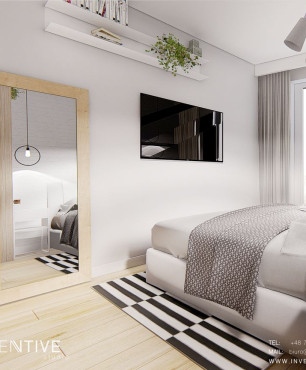 Sypialnia z łóżkiem kontynentalnym oraz z lustrem w drewnianej ramie