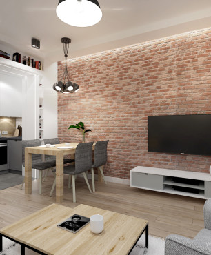 Salon z telewizorem zamontowanym na ścianie z cegły