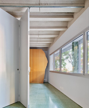 Wąski korytarz z betonowym sufitem oraz z zielonymi płytkami na podłodze
