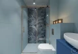 Łazienka z niebieskimi ścianami oraz z prysznicem