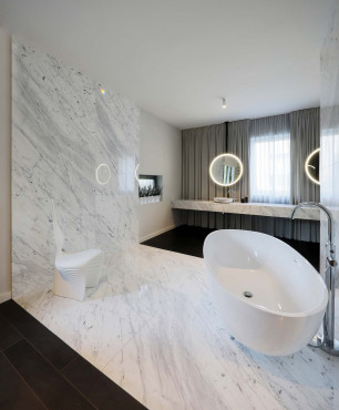 Wyjątkowa łazienka z wolnostojącą wanną i marmurową ścianą i podłogą