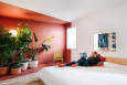 Duża sypialnia z drewnianym łóżkiem kontynentalnym oraz z kącikiem z roślinami