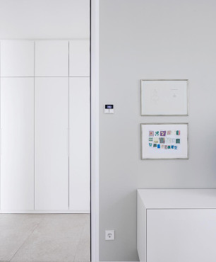 Jasny, klasyczny korytarz z białą, niska szafką stojącą