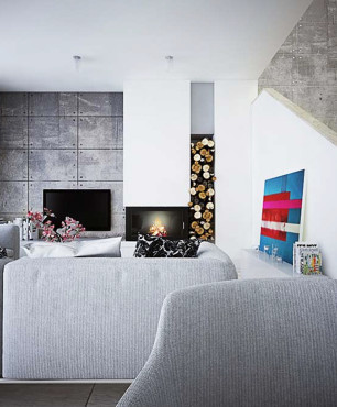 Salon z betonowymi płytami na ścianie oraz z kominkiem i miejscem do przechowywania drewna w ścianie