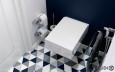 Łazienka z białą, prostokątną muszlą wiszącą oraz wzorzystymi kafelkami na podłodze