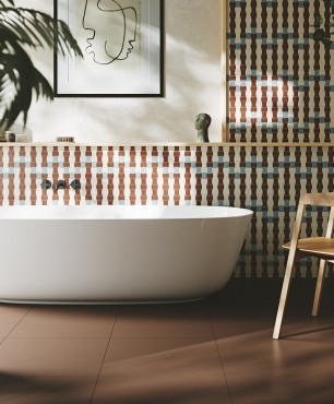 Łazienka z wanną ceramiczną oraz wzorzystymi płytkami na ścianie i brązową podłogą