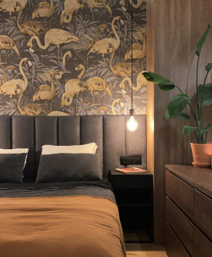Sypialnia z tapetą w ptaki na ścianie oraz z panelem tapicerowanym za łóżkiem kontynentalnym
