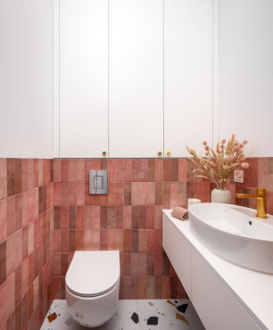 Kontrastowa łazienki z płytkami na ścianie w kolorze czerwonym oraz podłogą lastryko
