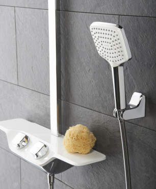 Prysznic w kolorze biało-szarym montowany do ściany z szarymi płytkami