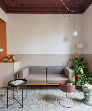 Mały, klasyczny salon z sofą oraz designerskimi stoliczkami