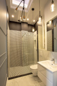 Nowoczesna łazienka z prysznicem oraz oryginalnym oświetleniem