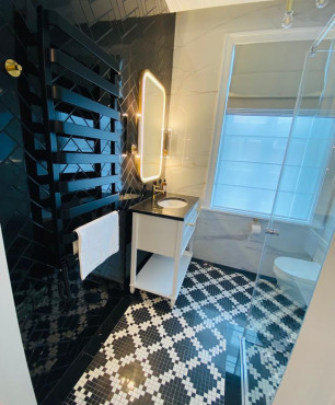 Nowoczesna łazienka hotelowa z biało-czarnymi płytkami na podłodze