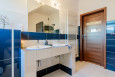 Klasyczna łazienka z dwoma umywalkami podblatowymi oraz brązowymi drzwiami