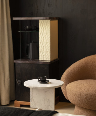 Salon z czarnym drewnem na ścianie oraz brązowym, tapicerowanym fotelem