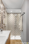 Łazienka z prysznicem oraz wzorzystymi płytkami na ścianie