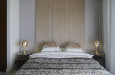 Sypialnia w stylu glamour ze  ścianą z elementami tapicerowanymi