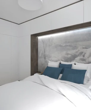 Sypialnia z białą szafą i szafkami w zabudowie z tapetą z motywem nieba