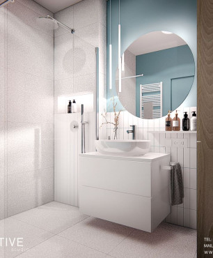Łazienka z prysznicem typu walk-in i białą szafką wiszącą